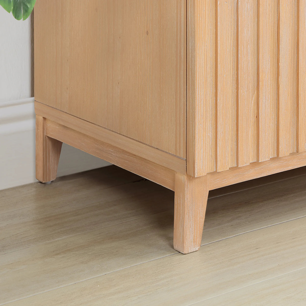 Grooved door fronts above an angled leg, Fir Wood Brown finish, shot near the floor