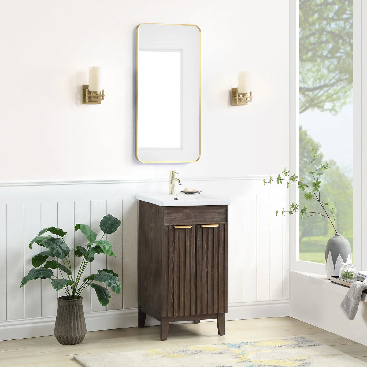 Wide shot of the Spruce Aged Brown cabinet and a rectangular wall mirror in a bath with white paneled walls