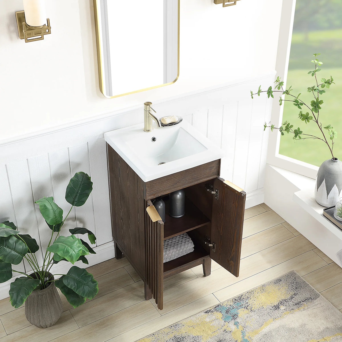 Doors swung open on the Spruce Aged Brown vanity to show the storage inside; a bath with white paneled walls