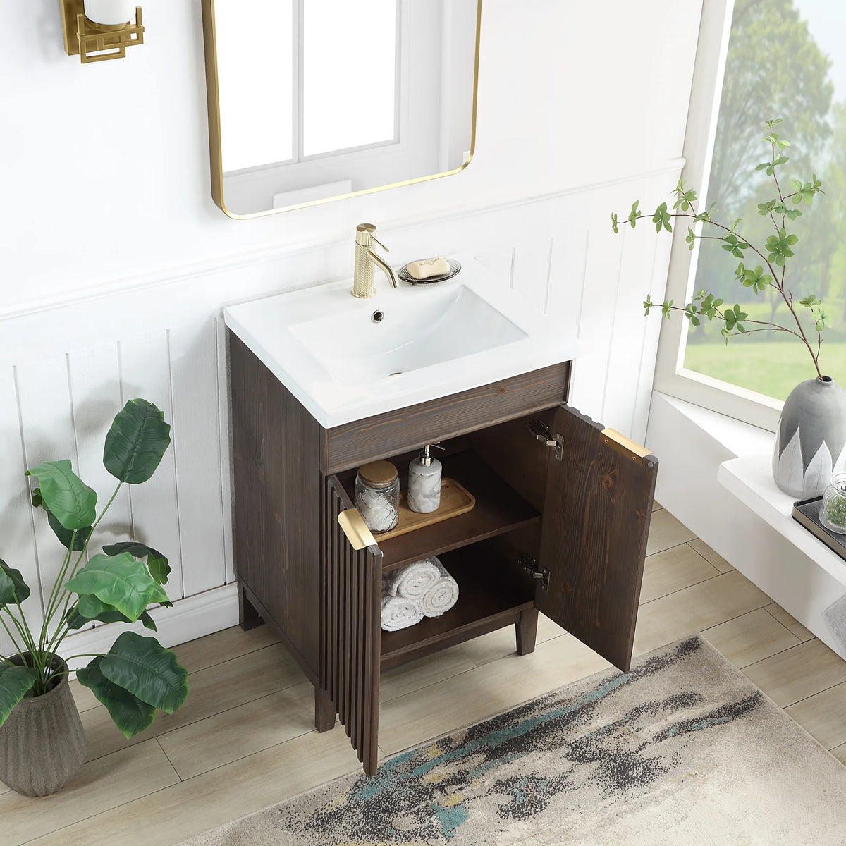 Doors swung open on the Spruce Aged Brown vanity to show the storage inside; a bath with white paneled walls